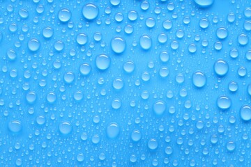 Water drops on blue background, top view