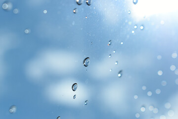 water drop on mirror with blue sky and white cloud background