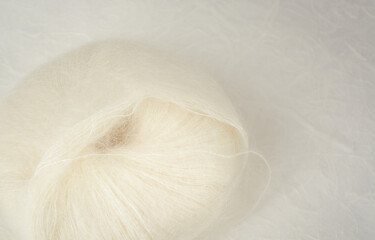 Obraz premium Ball of white mohair wool yarn with copy space