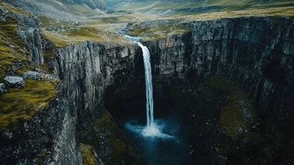 Aerial view of a waterfall in the wilderness, with a breathtaking landscape below