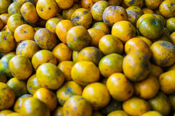 Close-up view of a pile of ripe mandarin oranges, showcasing their vibrant color and texture. Perfect for food blogs or showcasing seasonal produce.