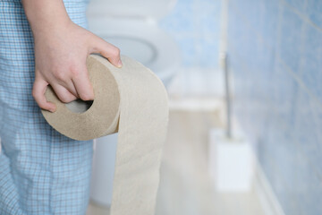 Little boy learning hygiene rules, standing with toilet paper roll, Child mastering toilet training...