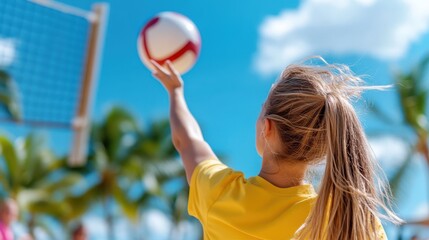 A girl wearing a yellow shirt enthusiastically hits a volleyball in an outdoor setting under the vibrant blue sky, capturing youthful energy and competitive spirit.