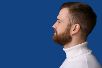 Fototapeta premium Handsome bearded man on blue background, closeup