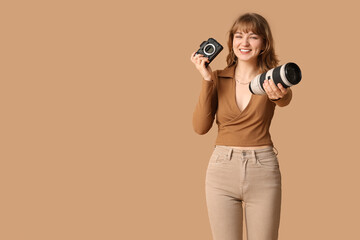 Beautiful young woman with modern camera and lens on brown background