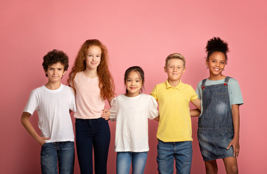 Back to school concept. Happy diverse boys and girls posing on pink background