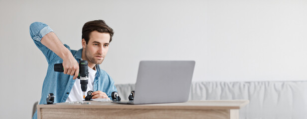 Online lesson and instructions for assembling furniture with own hands. Concentrated young handsome...