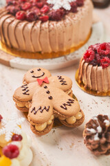 A festive gingerbread man cookie decorated with red icing takes center stage on a white plate, surrounded by holiday-themed cookies shaped like reindeer and snowflakes. The warm and cozy Christmas set