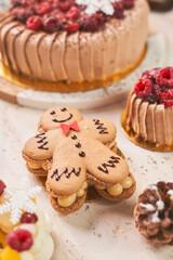 A festive gingerbread man cookie decorated with red icing takes center stage on a white plate, surrounded by holiday-themed cookies shaped like reindeer and snowflakes. The warm and cozy Christmas set