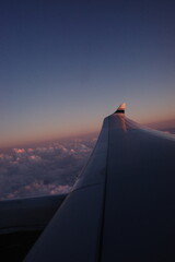 Airplane in the Sky with Pink Clouds Seen from Window View &ndash; Scenic Travel Perspective
