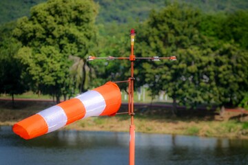 Orange and White Striped Windsock Marker in Rural Landscape