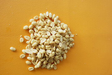 Aesthetic CloseUp Image of Roasted Peanuts Set Against a Bright Orange Background