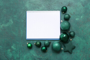 Notebook with Christmas balls on green grunge background