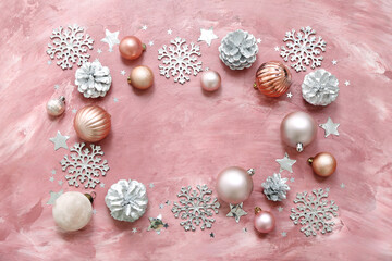 Frame made of Christmas balls, decorative snowflakes and cones on pink grunge background