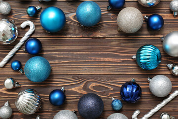 Frame made of Christmas balls and candy cane toys on wooden background