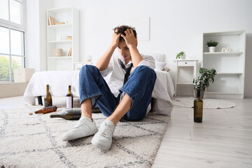 Drunk young man at home. Alcoholism concept