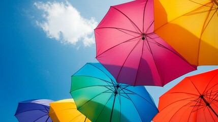 Vibrant rainbow umbrellas against a clear blue sky, symbolizing diversity, joy, and protection. A colorful display of optimism and unity on a bright sunny day.