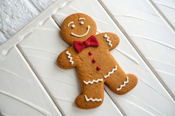 Gingerbread man, ready for the festivities, with a bold red bow tie.