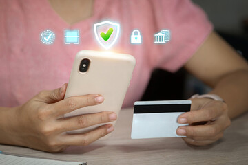 A person holding a smartphone and a credit card, with digital security icons above, representing safe online payment.