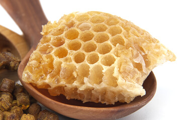 A detailed view of a honeycomb piece resting on a wooden spoon