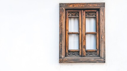 A rustic wooden window with intricate carvings, framed against a white wall.