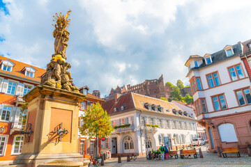 The fountain statue of Kornmarkt Madonna Mary, Mother of God in Kornmarkt Square, with the castle above in the Altstadt old town of the Bavarian city of Heidelberg, Germany	