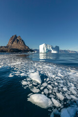 View of an iceberg with an arch and Uummannaq island, Greenland, floating ice © PetraJPhoto