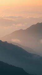 Misty mountain range at sunrise with peaks shrouded in fog, hazy, foggy, scenery