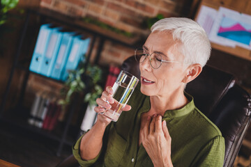 Photo of elderly attractive lady wear shirt drink pills suffer pain workplace workstation loft interior indoors