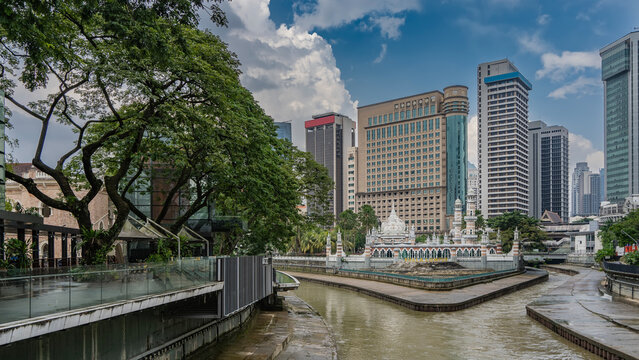 The historical quarter of Kuala Lumpur. An ancient Masjid Sultan Abdul Samad mosque at the confluence of two rivers. Weathered steps, a gallery with arches and columns. Domes with spires. Malaysia.