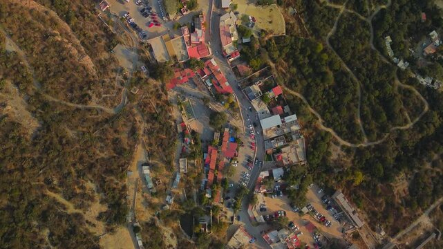 Amazing aerial view of the town of Bernal in Queretaro Mexico, houses in the forest like favelas of a tourist place, with cars and streets
