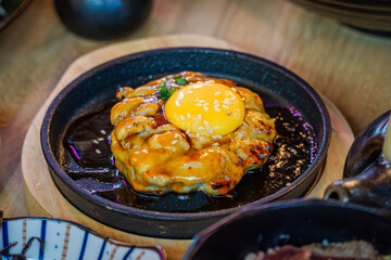 Tsukimi Chicken Teppanyaki Minced Chicken Seasoned with Original Recipe, grilled on a hot plate until cooked, topped with Teriyaki Sauce and topped with Egg Yolk.
