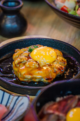 Tsukimi Chicken Teppanyaki Minced Chicken Seasoned with Original Recipe, grilled on a hot plate until cooked, topped with Teriyaki Sauce and topped with Egg Yolk.