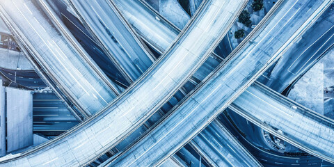 Aerial photograph of modern urban highway with intricate overpasses and lanes, showcasing complexity of city infrastructure and transportation