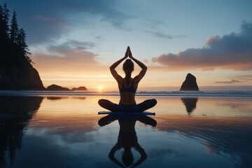 A woman is sitting on a mat on the beach, practicing yoga