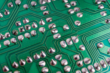 The back side of an electronic circuit board with connecting tracks close-up
