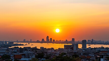 Naklejka premium Majestic Sunset Over City Skyline with Reflections on Water and Silhouetted Buildings Creating a Serene Evening Atmosphere in Urban Landscape