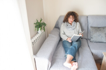 Relaxed Lady Reading A Book In A Cozy Room With Natural Decor, Promoting Ideas Of Self-Improvement, Learning, Relaxation, Indoor Lifestyle, And Enjoying Peaceful Moments At Home