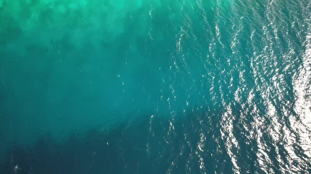 Madrisky island in los roques with sunlight reflecting on clear turquoise waters, aerial view