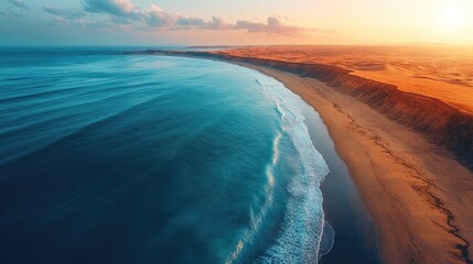 Aerial view of desert coastline showcasing sandy shores merging with tranquil ocean waves under picturesque sunset sky