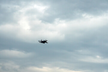 A military aircraft in a cloudy sky. An aviation show with aerobatics demonstrations. Air force Sukhoi SU-30 Flanker