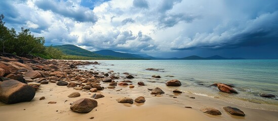 Serene northern beach landscape with rocky shoreline and dramatic cloudy sky over calm ocean waters