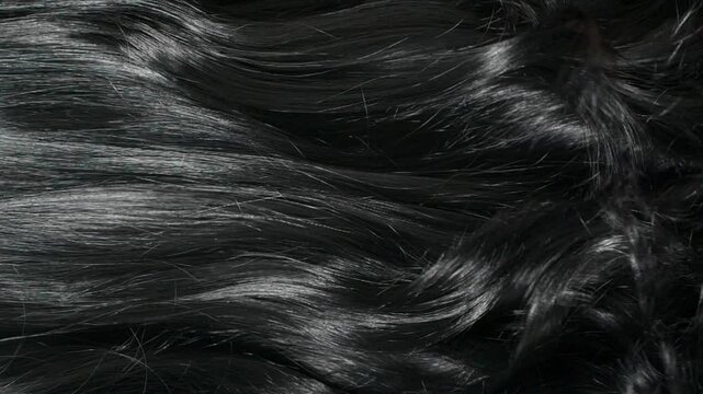 Closeup beautiful female black long curly hair texture background in slow motion