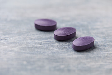Lutein tablets. Dietary supplement on wooden background. Soft focus. Close up. Copy space