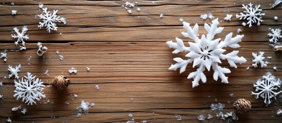 Decorative paper snowflakes and pinecones scattered on rustic wooden surface for winter or holiday themed backgrounds