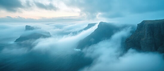Obraz premium Mystical fog enveloping rugged cliffs with the ocean waves below under a serene twilight sky