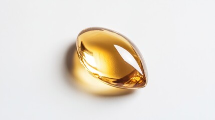 Isolated golden oil droplet with a smooth, glossy surface resting on a clean white background, showcasing its vibrant color and elegant shape.