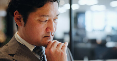 Thinking, businessman and ideas in office, serious and planning for opportunity, investor and stock market. Finance, wondering and Asian person in corporate, contemplating and stockbroker in Japan