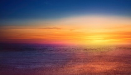 Obraz premium Golden Hour Horizon: A breathtaking sunset paints the sky in vibrant hues of orange, pink, and purple, casting a warm glow on the clouds below. The sun dips below the horizon.