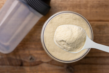 保存瓶から計量スプーンですくい取ったプロテインパウダーの俯瞰